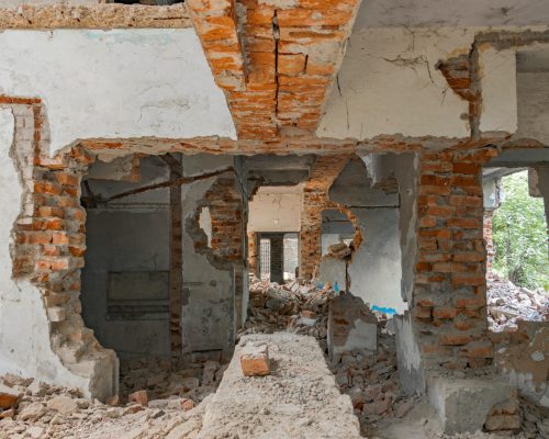 Explore the decaying ruins of an abandoned building with exposed bricks and destruction.